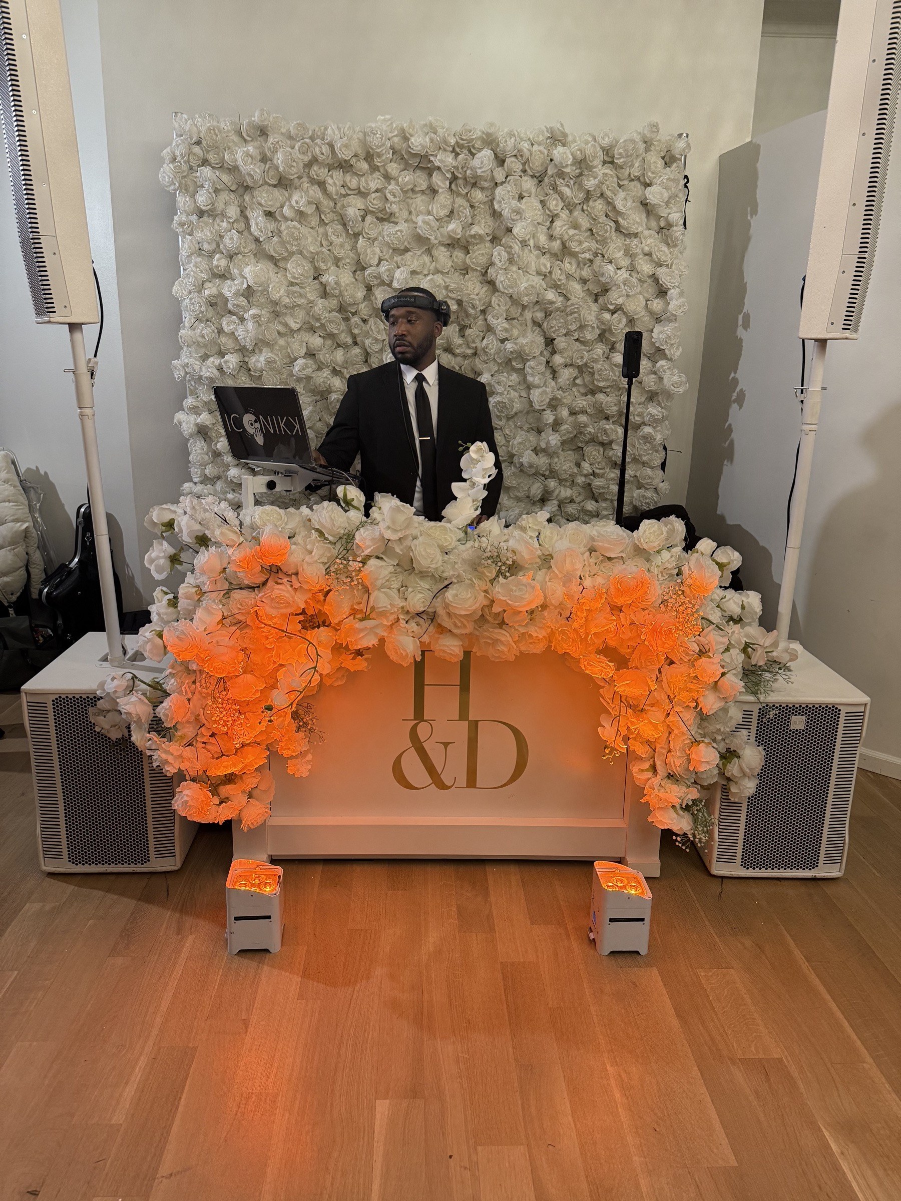 Genesis Events DJ at a flower-wall booth with custom monogram at The Mansion at Glen Cove