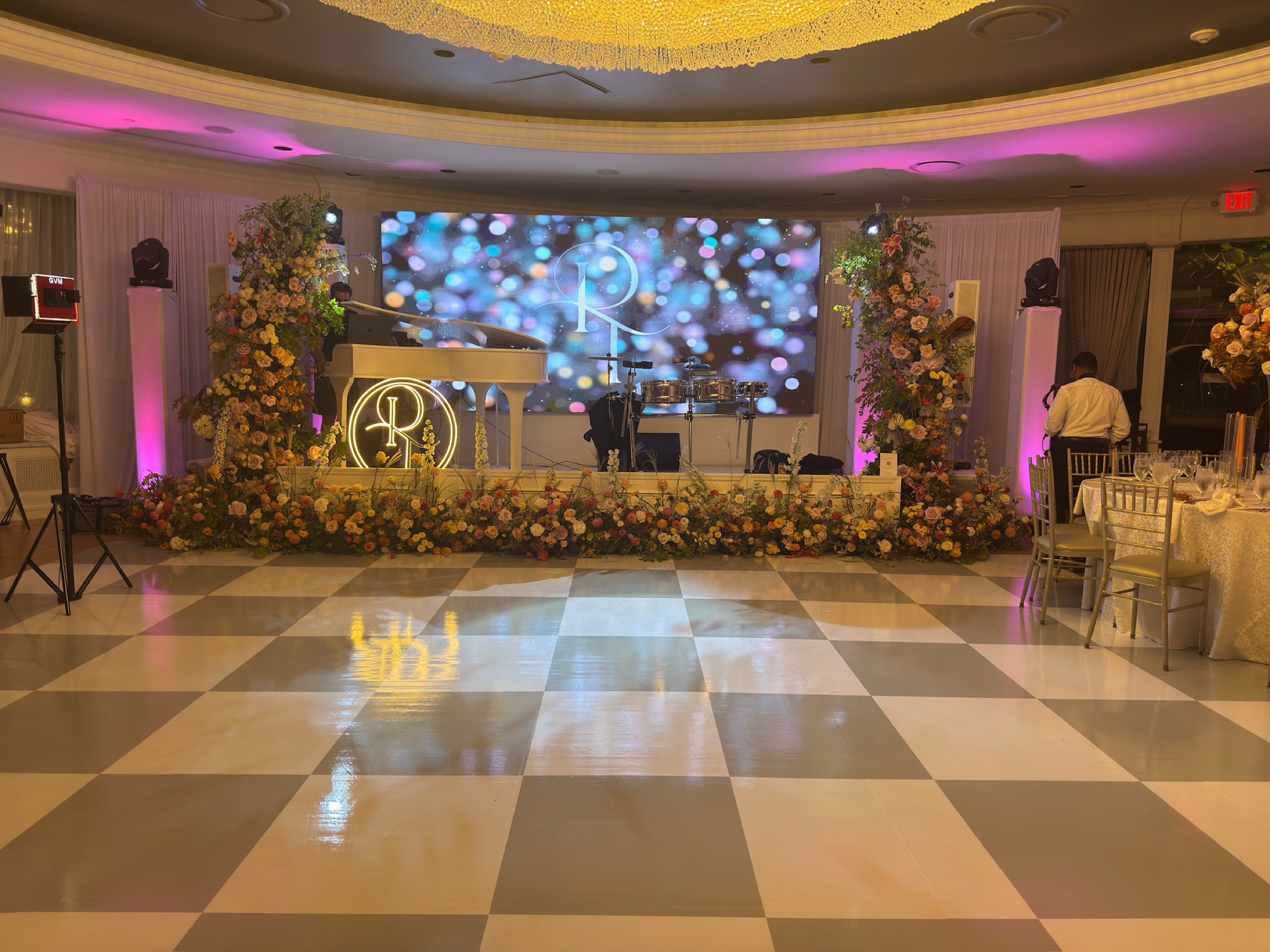 Custom LED wall framed by florals at a Mansion at Glen Cove wedding reception
