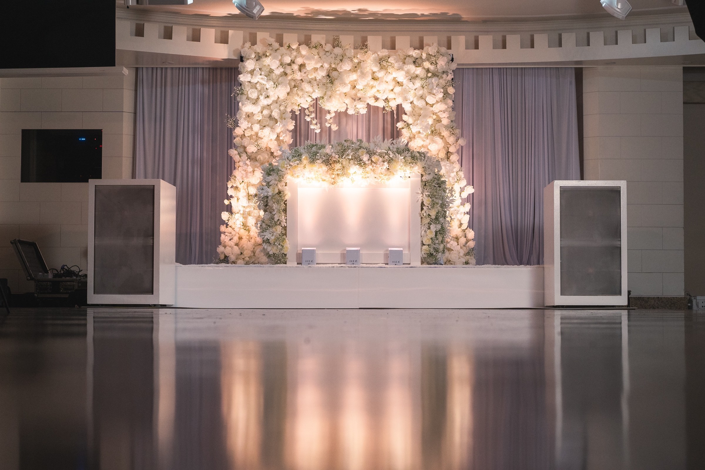 All-white custom DJ setup with floral backdrop at Sand Castle