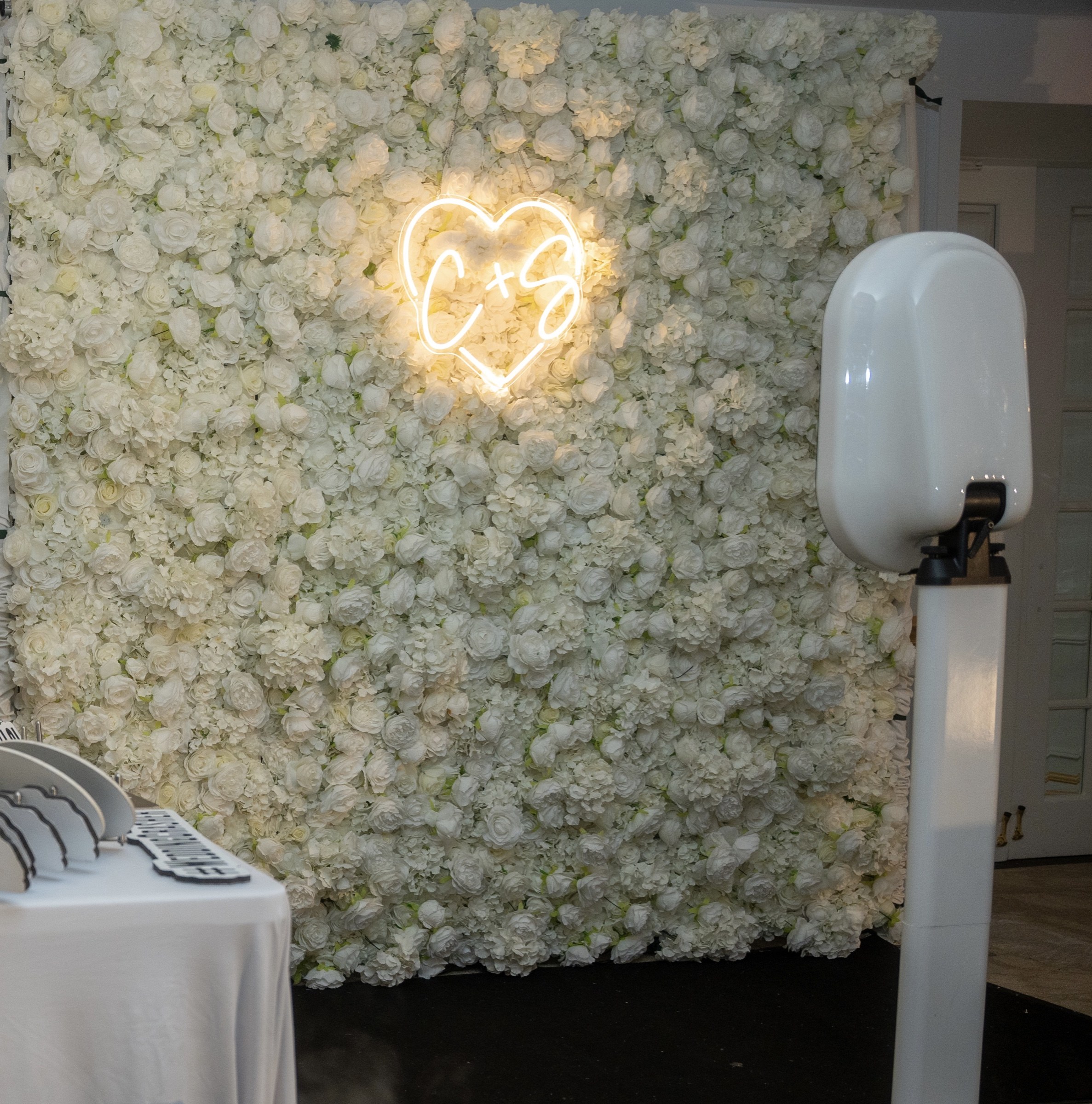 Flower wall with neon heart and photo booth at Sand Castle