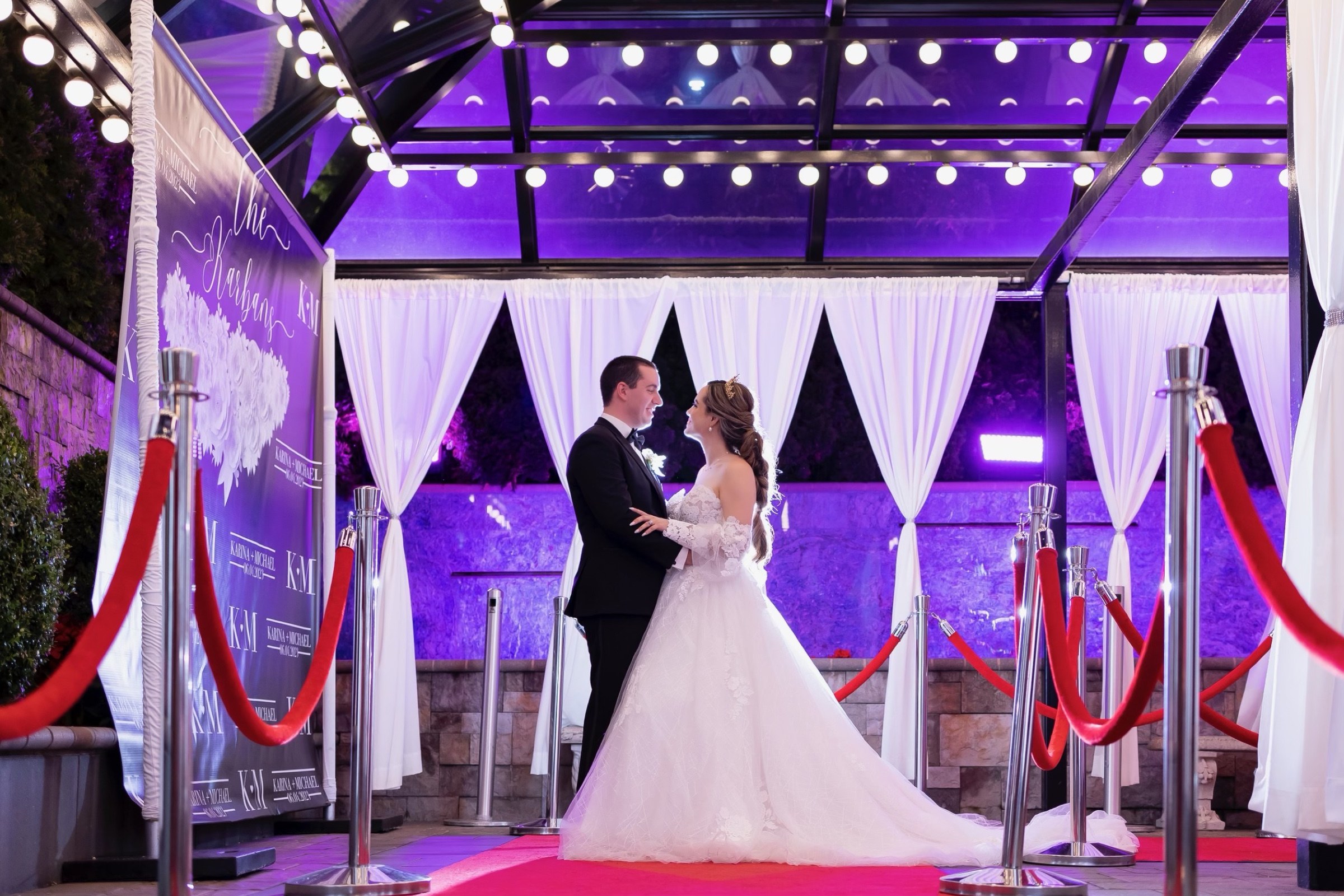 Couple on the red-carpet glam entrance in the glass atrium at Sand Castle
