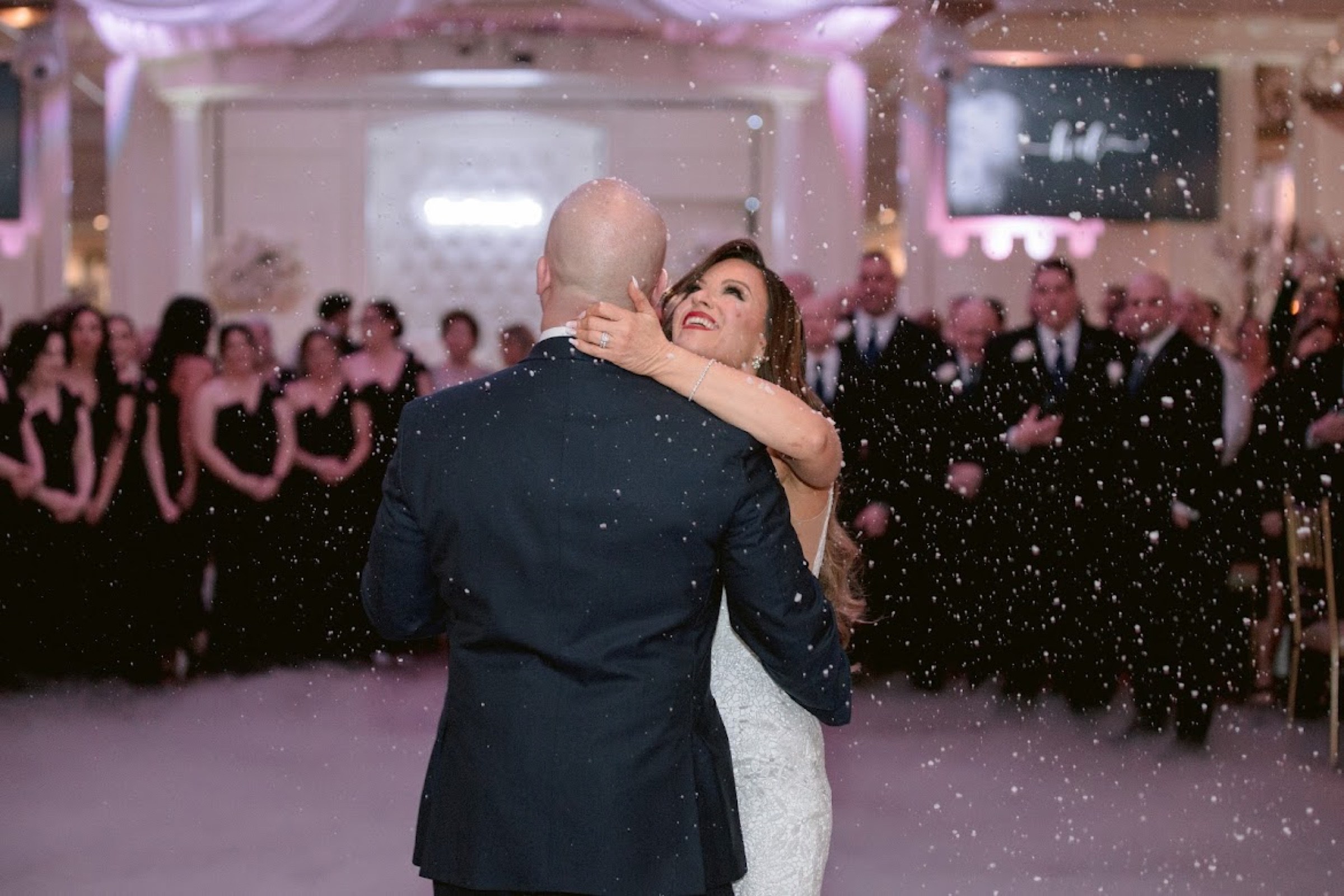 First dance in falling snow effect surrounded by guests at Sand Castle