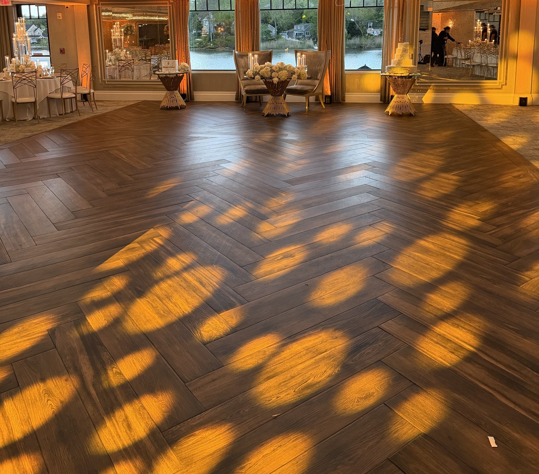 Amber gobo lighting design across the Water's Edge dance floor with water views through the windows
