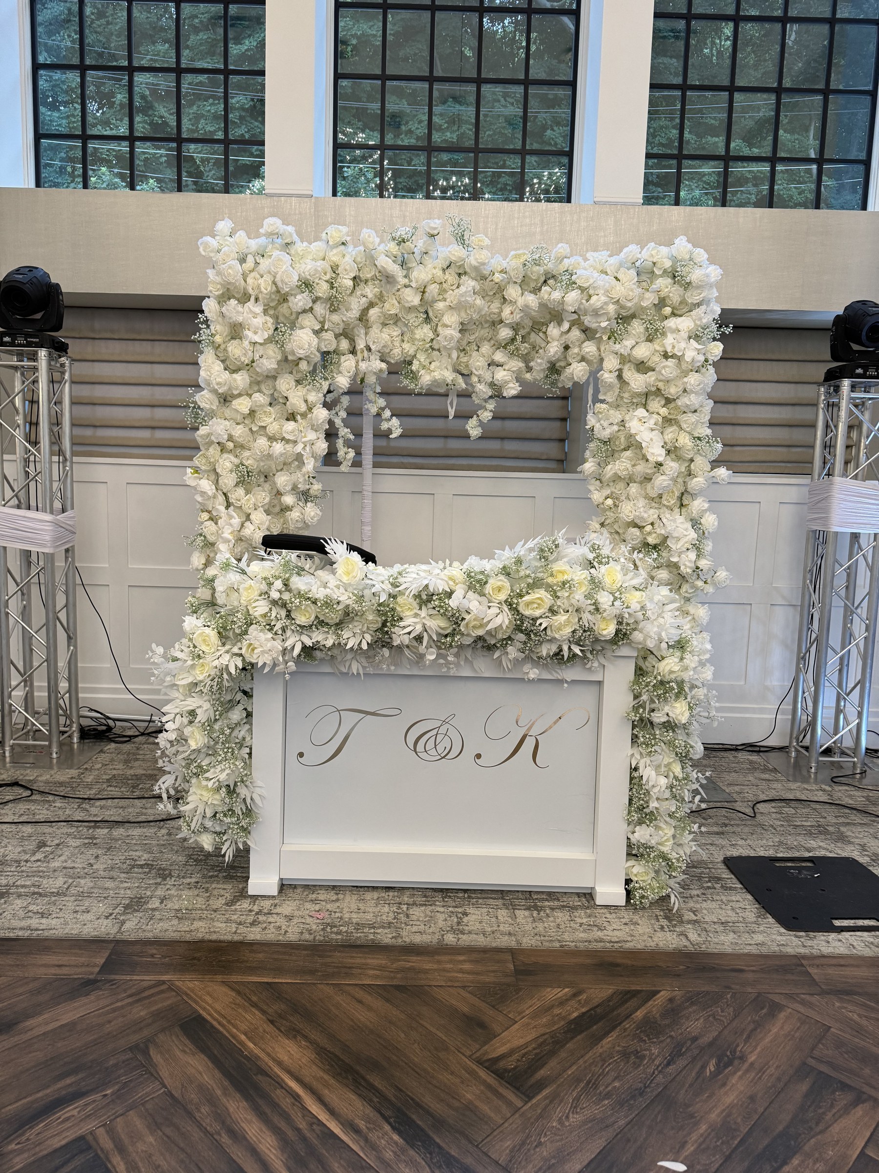 Floral-framed DJ booth with truss lighting at a Water's Edge wedding in Centerport